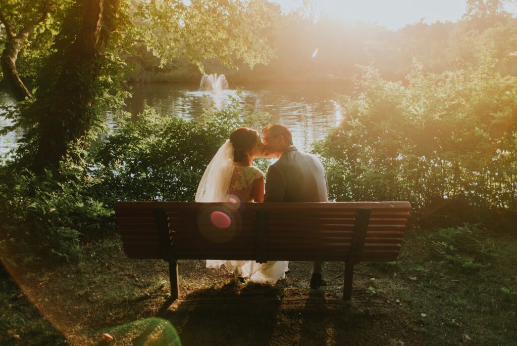 Retrato de una pareja de bodas al atardecer frente a un lago