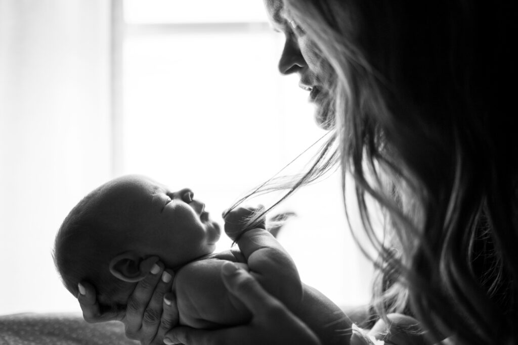fotografia a blanco y negro de una madre con su bebé en brazos